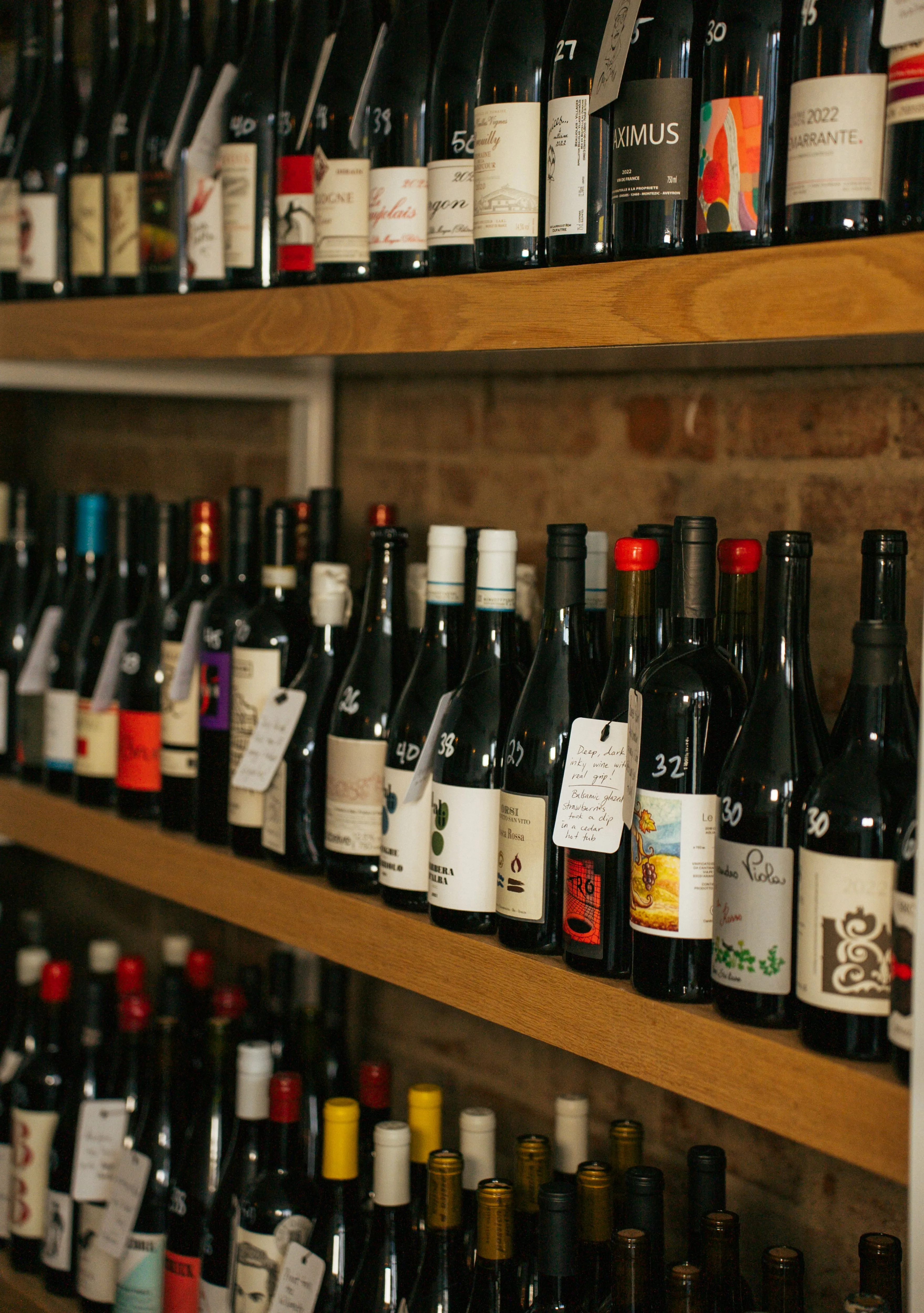Curated wine bottles arranged on warm wooden shelves in a boutique shop